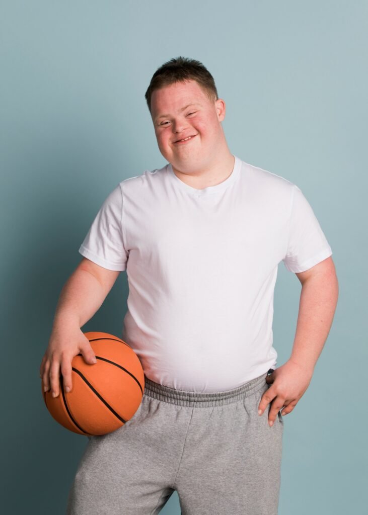 Cute athletic boy with down syndrome holding a basketball